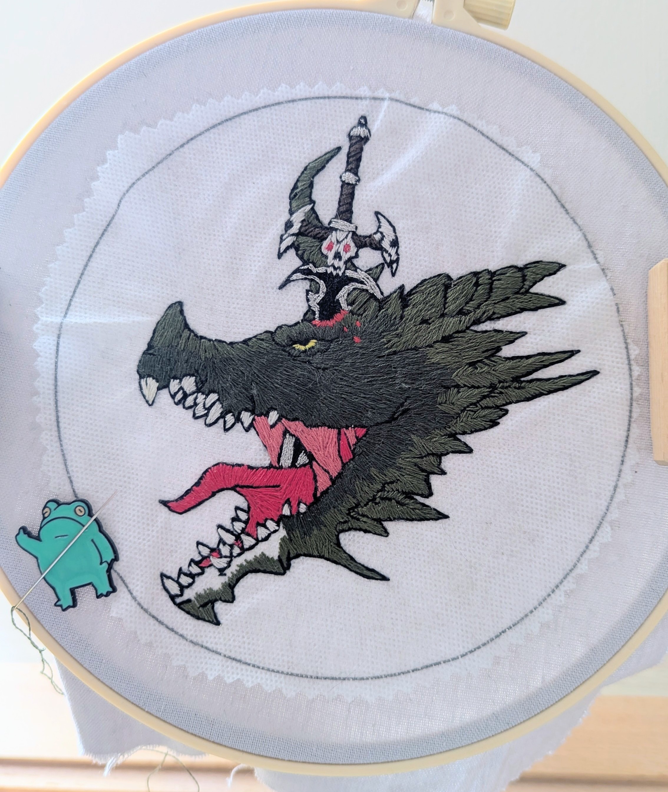 Hand embroidery on a hoop, showing a detailed thread-worked dragon design.